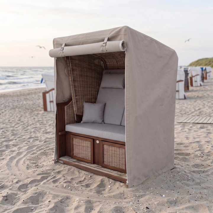 Strandkorb-Schutzhülle nach Maß in Beige über einem Strandkorb am Strand